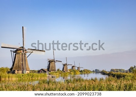 Horizontal picture of the famous Dutch windmills at Kinderdijk, a UNESCO world heritage site. On the photo are five of the 19 windmills at Kinderdijk, South Holland, the Netherlands, which are built
