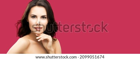 Portrait of beautiful young woman, isolated over red background, with copy space, for some text or slogan. Brunette girl in studio shot. Beauty, health and skin care concept picture.