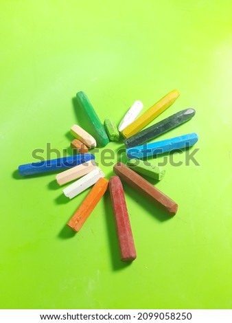 a broken crayon that hasn't been used for a long time, in the photo with an isolated green background