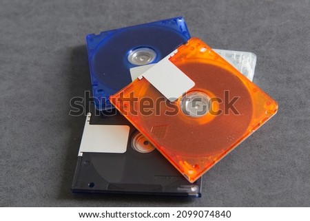 select focus of mini disc for data and music record with white background, Colorful mini disks - beautiful retro disks, mini md disk in hand woman with background red color.
