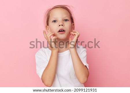 Portrait of happy smiling child girl emotion hands gesture pink background