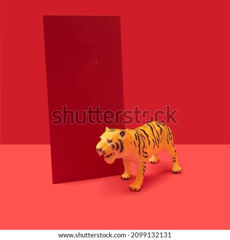 Modern concept of Chinese tiger zodiac new year celebration with red card beside. Red background behind.