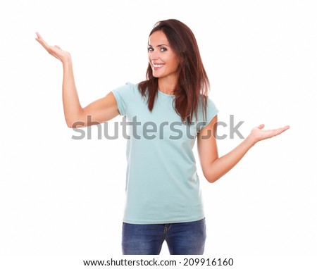Portrait of lovely woman on blue jeans holding her palms up while standing and smiling at you on isolated white background - copyspace