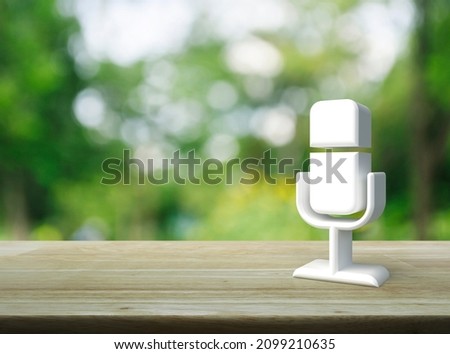 Microphone 3d icon on wooden table over blur green tree in park, Business communication concept
