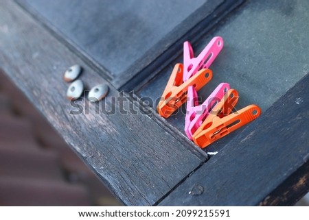 A bunch of clothespins in the corner of a window.