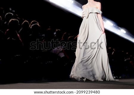 A fashion model at a catwalk during a fashion show or fashion week.