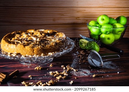 The picture shows a beautifully decorated apple pie on a rustic table