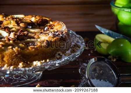 The picture shows a beautifully decorated apple pie on a rustic table