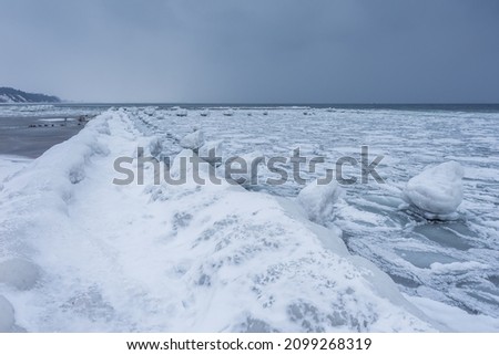 Frozen wooden breakwaters line to the world war II torpedo platform at Baltic Sea. Frozen morning at Babie Doly, Poland. Long exposure photo.