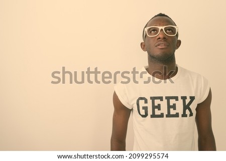 Studio shot of young African man as nerd with eyeglasses against white background