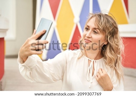Young woman doing self portrait outside. City vacation portrait. Blogger selfie video. Travel local. Alone tourist. Happy emotion. Smiling female person. Lifestyle action. Posing