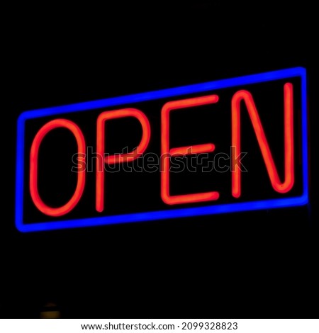 a neon open sign in a black background