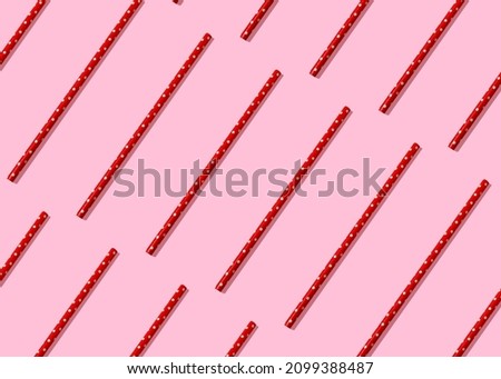 Red paper straw with white polka dots isometric pattern. Minimal party cocktail drink or valentines day minimal concept. Flat lay.