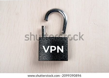 broken padlock with inscription VPN on a wooden background top view