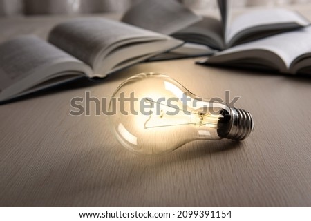 burning glass bulb on the background of books 