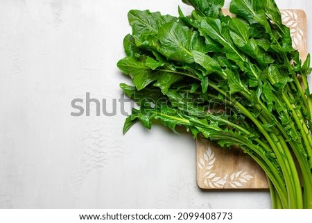 Chicory greens, fresh leaves of chicories on white table, ready to be cooked. Copy space. Royalty-Free Stock Photo #2099408773