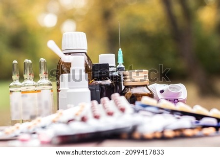 Colorful pills and capsules on wooden table, nature bokeh background