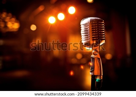 Retro microphone on stage in restaurant. Blurred background Royalty-Free Stock Photo #2099434339