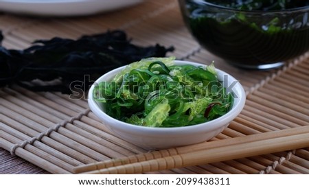 Chuka wakame is salad from green seaweed. Seaweed salad with sesame on a white small cup.