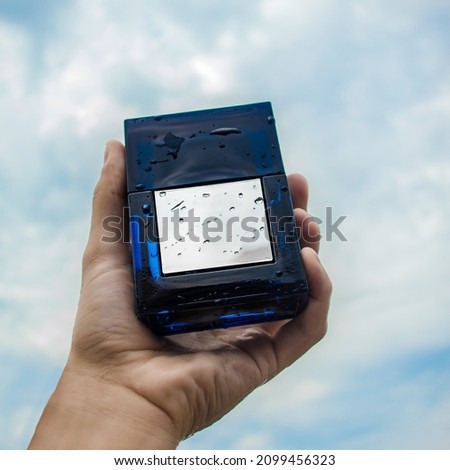 blue perfume bottle with sky in the background