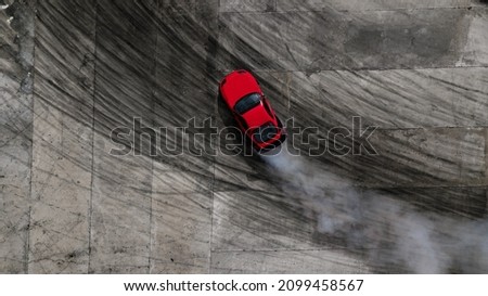 Aerial top view professional driver drifting car on asphalt road track with white smoke, Automobile race car drift on abstract asphalt road with black tire skid mark, View from above. Royalty-Free Stock Photo #2099458567