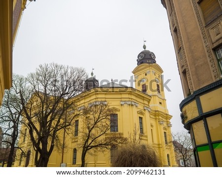 Protestant Great Church, Hungarian: Reformatus Nagytemplom, on the Kossuth square in Debrecen, Hungury. Close up of yellow buildings with two towers, clocks, columns and windows on the sky background
