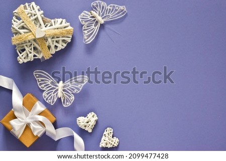 Flat lay composition. Mockup of holiday card for mothers day, valentines day, womans day. Table top view gift box, hearts with butterflies on Very Peri background. Violet tone design