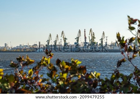 photo of a loading dock with ships and cranes in the background. space for printing text. background picture.