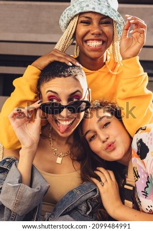 Female friends having fun together outdoors. Group of generation z friends making funny faces while hanging out together in the city. Happy young friends spending quality time together. Royalty-Free Stock Photo #2099484991