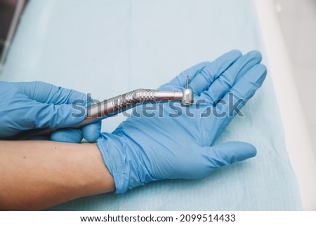 Dentist Hand Latex Glove New High Speed Dental Handpiece Medical Instrument Concept Royalty-Free Stock Photo #2099514433