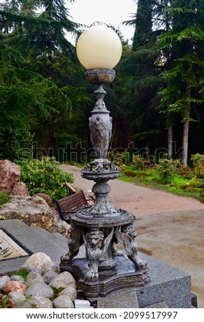 A beautiful lantern in the shape of a ball on a beautiful pedestal in the park of Crimea. Decorative lamp in Partenit park.