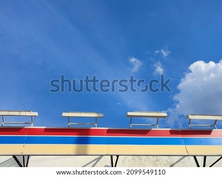 The roof terrace of a convenience store against a bright blue sky background