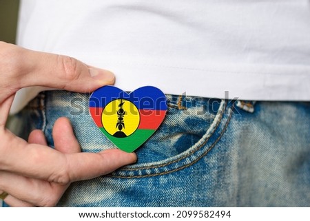 Patriot of the New Caledonia! Wooden badge with New Caledonian Flag in the shape of a heart in a man's hand.