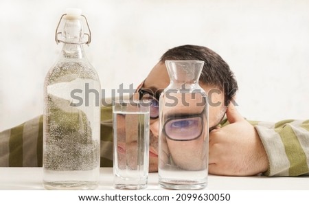 surreal portrait of a strange man looking through glasses of water. man looking through glass glasses of water with reflections and distortions. isolated on white background.