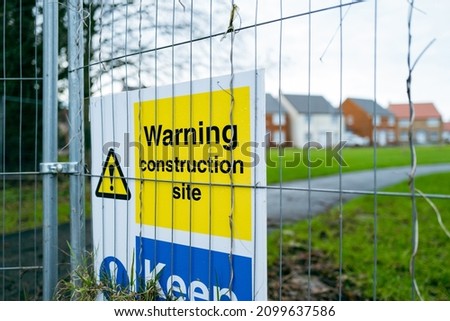 Shallow focus of generic warning signs seen at the edge of a new housing development.