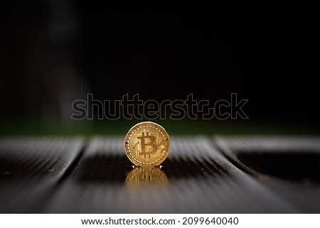 a bitcoin coin stands in the rain