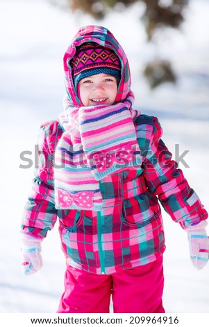 beautiful little girl walking in winter park. snow, sunny winter day