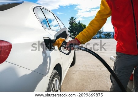 Man pumping gasoline fuel in car at gas station and being fill gas tank of white car in gas station, Concept of Global Fossil Fuel Consumption, Rising gasoline prices, Copy Space. Royalty-Free Stock Photo #2099669875