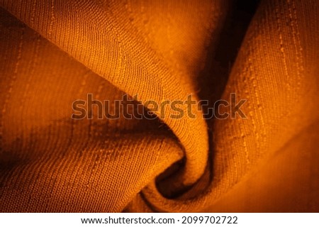 Brown and yellow fabric, dark amber silk, bright sunny abstract background illustration. Decorative items close-up. Wallpaper texture, background Royalty-Free Stock Photo #2099702722
