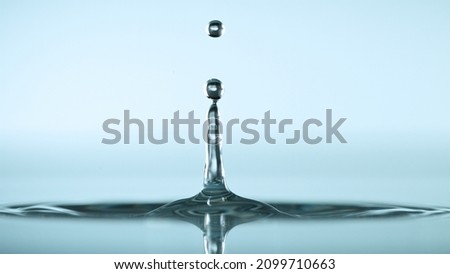 Water splash isolated on light blue background, macro shot.