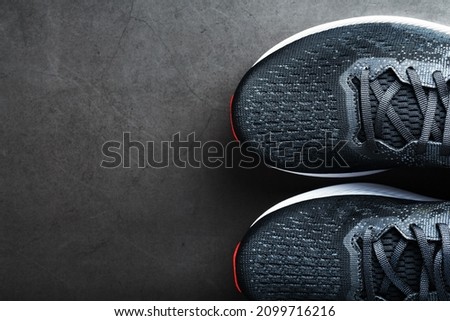 Black sports sneakers for training on a dark background with a minimalistic concept
