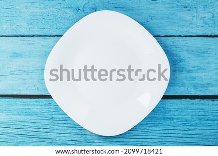 Empty round bowl on a blue wooden background from above. Free space
