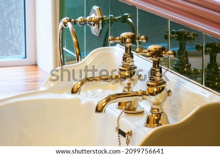 New luxury hotel vintage brass gold plated pillar taps in ensuite bathroom at wash basin Royalty-Free Stock Photo #2099756641