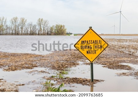 Road closed sign and high water flooding roadway. Storm and rain damage, weather warning and climate change concept.