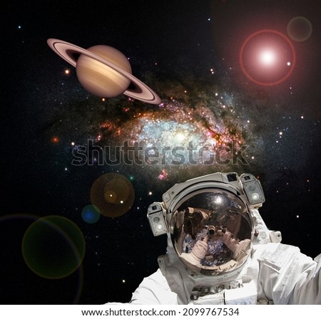 Astronaut and Saturn. Fascinating dark space. The elements of this image furnished by NASA.

