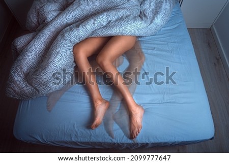 Woman sleeping in the bed and suffering from RLS or restless legs syndrome Royalty-Free Stock Photo #2099777647