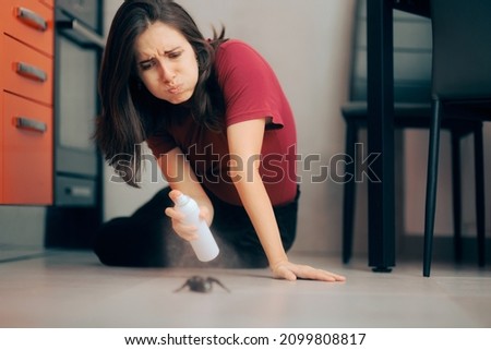 
Woman Spraying with Insecticide Over an Ant on the Kitchen Floor. Homeowner dealing with pest infestation problem in her own apparent
 Royalty-Free Stock Photo #2099808817