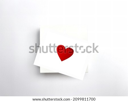 Red heart card on a white box against a white background as symbol of a Valentine’s Day card, clipping path 