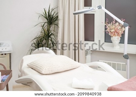 Modern empty dermatologist cosmetologist massage table for cosmetic procedures in the beauty clinic. Empty aesthetic medicine salon Royalty-Free Stock Photo #2099840938