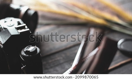 Negative film on a black wooden table and 2 vintage film cameras.